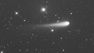 a fuzzy white orb leaves a tail behind it as it soars past background stars, which appear as streaks